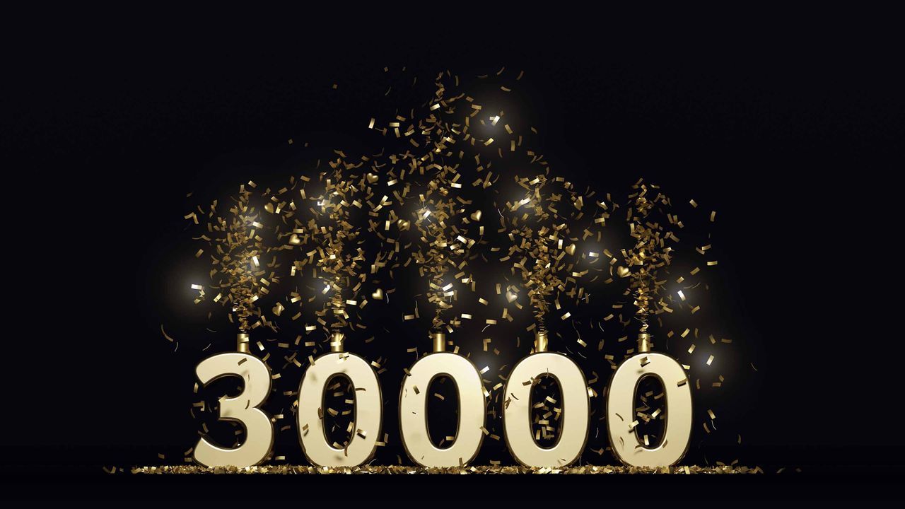 The number 30,000, but with sparkler candles coming out of the tops of each number