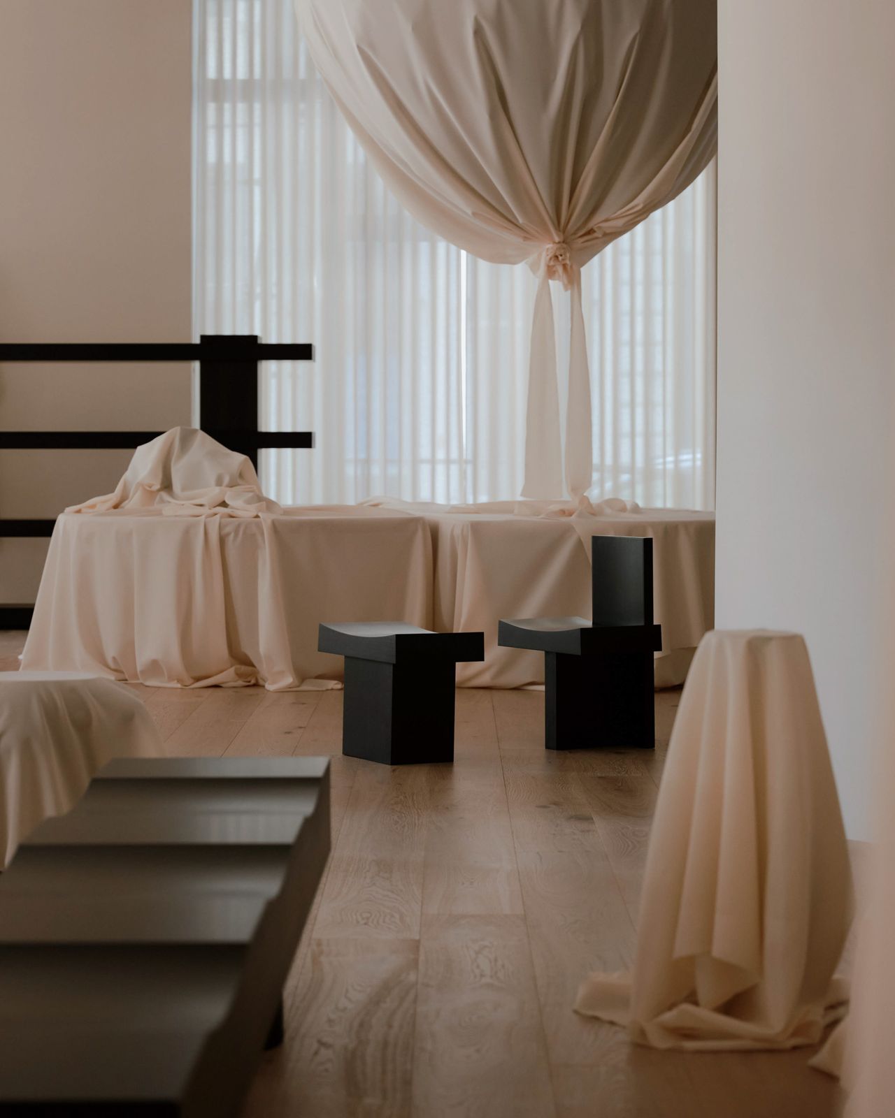 A design showroom is entirely covered in soft, cream textile and wooden furniture in simple, minimalist lines.
