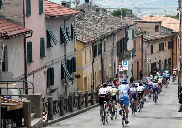 The peloton passing a scenic Italian village.