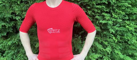 Man wearing red short sleeved base layer by hedge