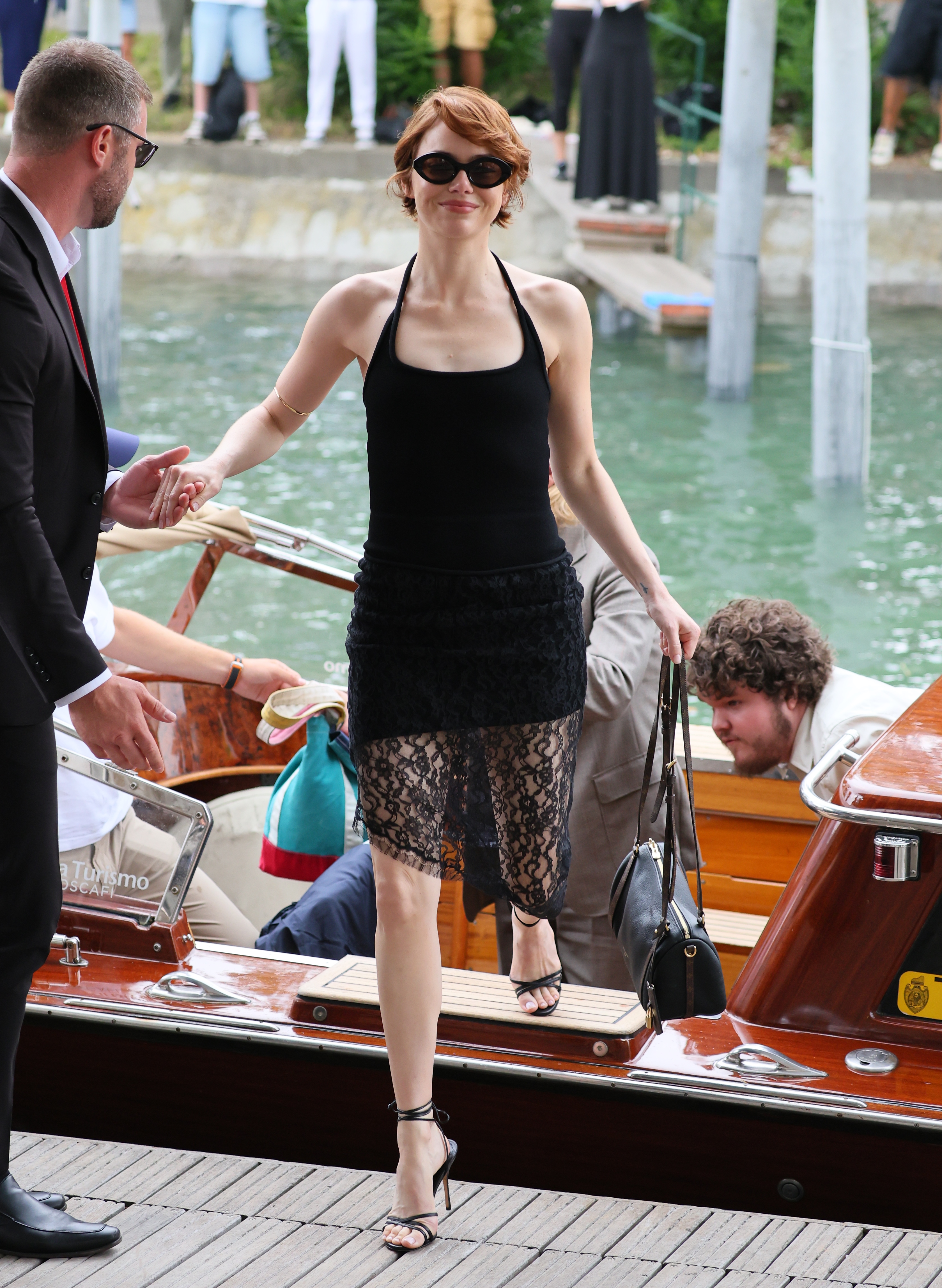 Emma Stone arrived at the Venice Film Festival in a lacy little black dress and a Louis Vuitton handbag