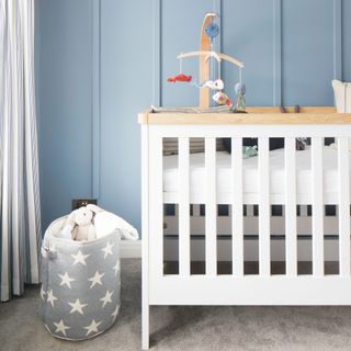 Nursery bedroom with white cot and light blue panelled walls