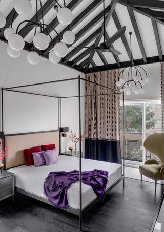 A bedroom with a big lighting piece