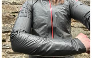 This image is a close up of a women's torso with her left arm folded across her torso wearing the Castelli Idro 3 W jacket