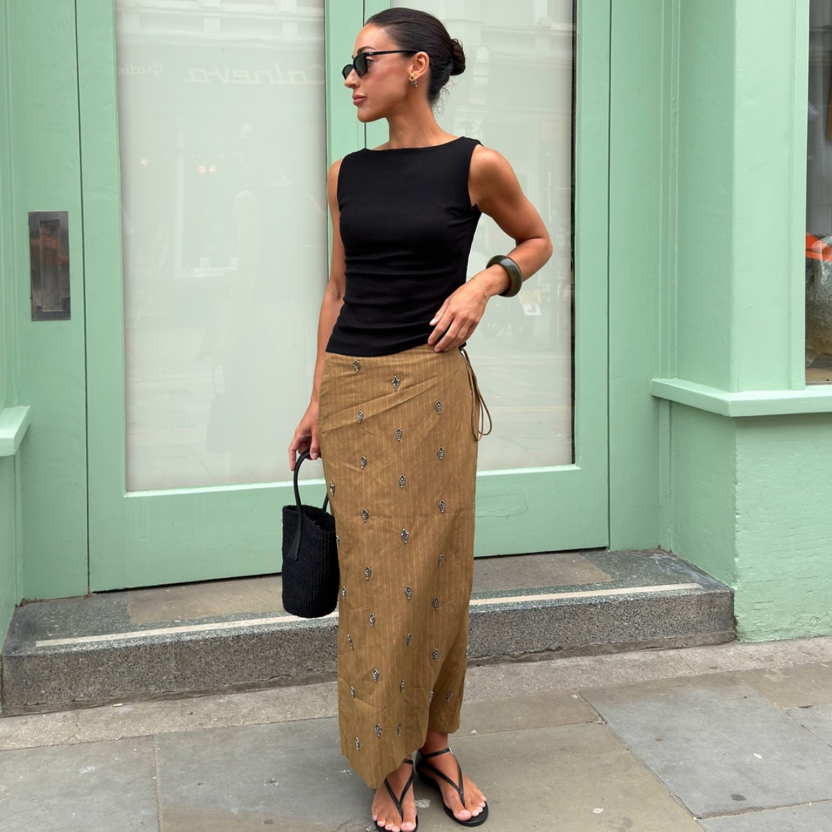 An image of a woman wearing black top and wrap skirt summer 2026
