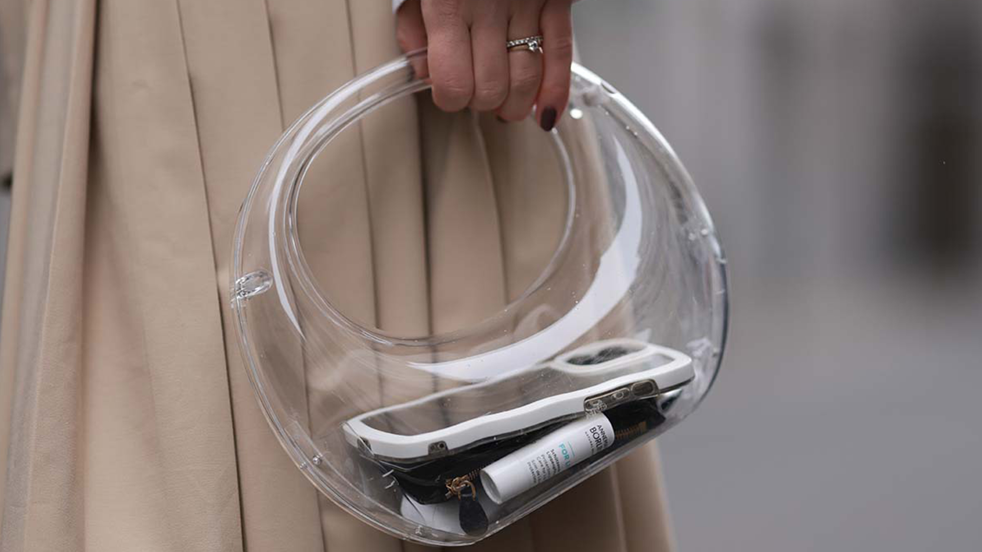 A woman holds a clear bag.