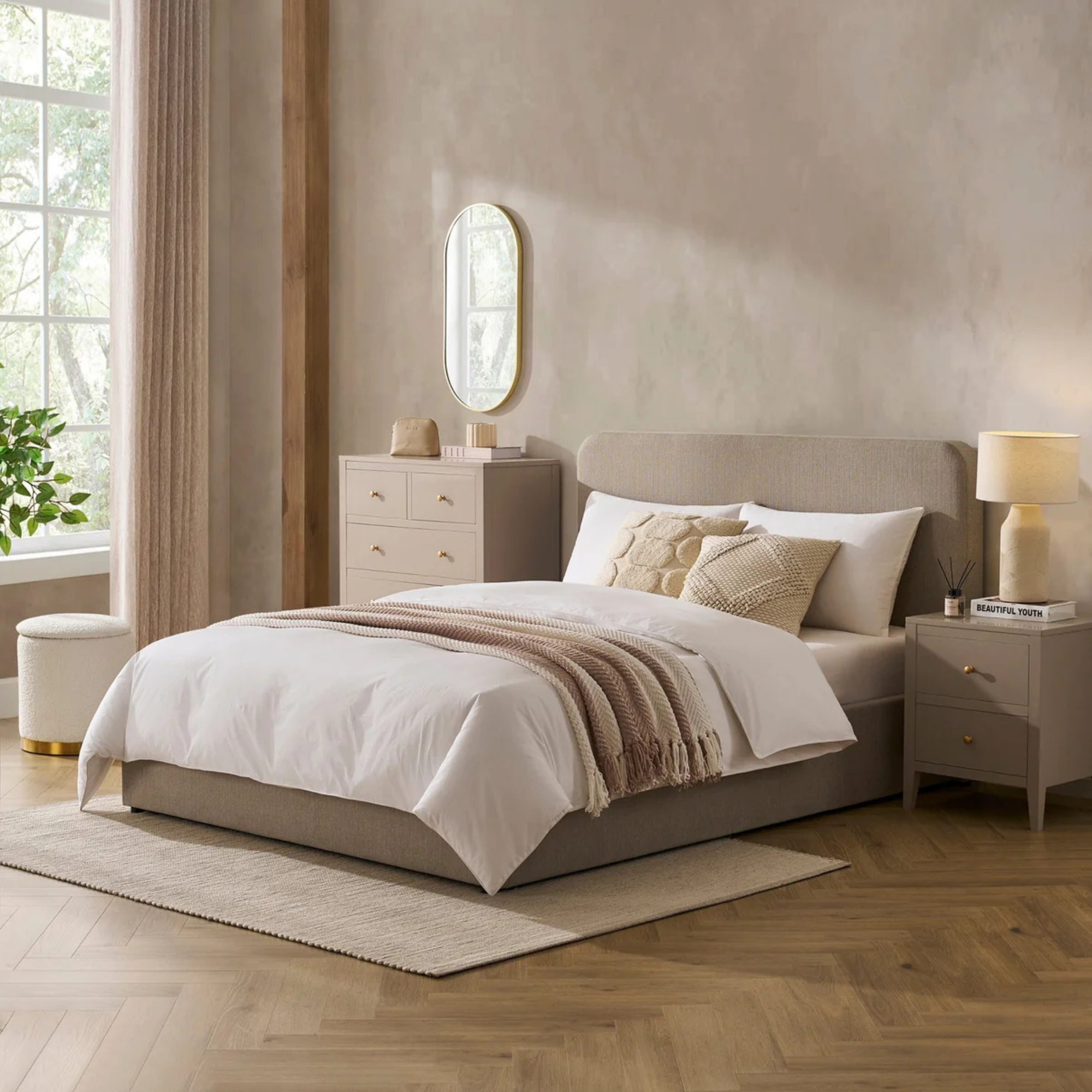 Dusk Ascot Ottoman Storage Bed in Stone Grey with neutral duvet, throw and cushions in a taupe bedroom.