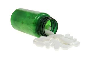 A green bottle of magnesium pills spills out.