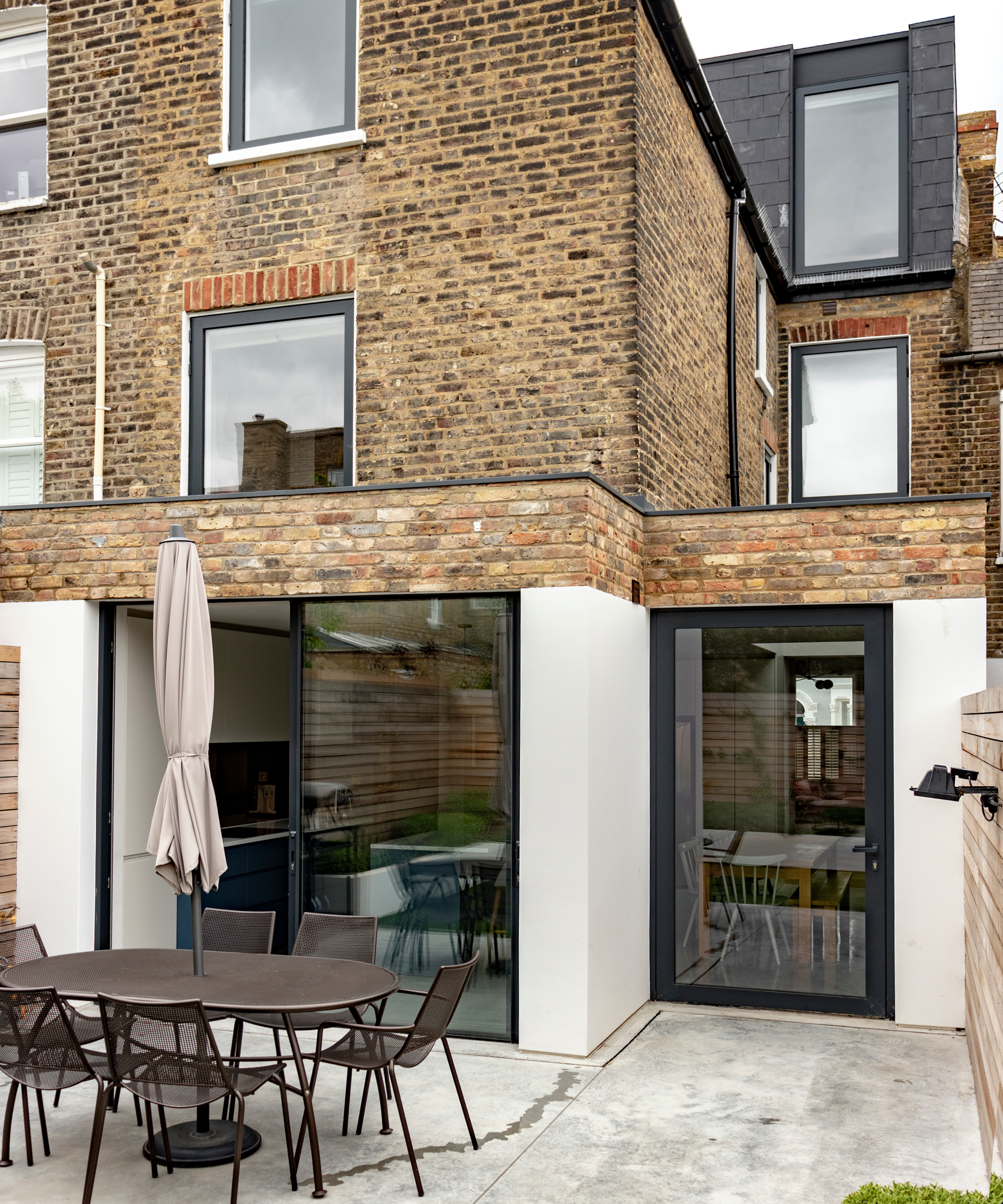 brick and cream render wrap around extension on terraced house with side return stepped back from rear extension