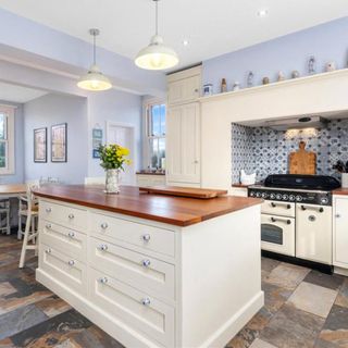 kitchen with wooden worktop and stone flooring