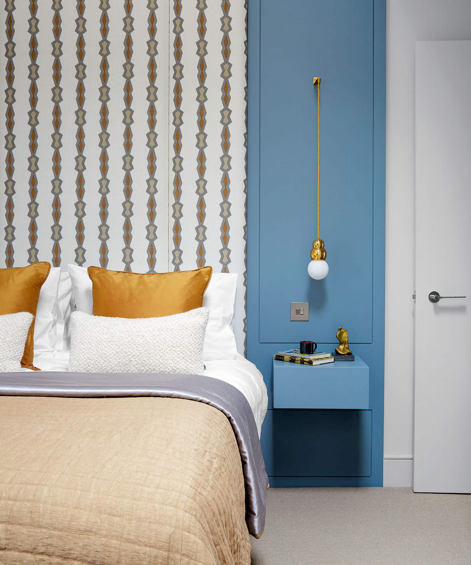 Small bedroom illustrated with a bright blue wall and statement wallpaper.