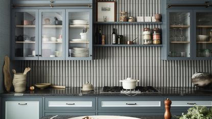 should I use handles or knobs on kitchen cabinets, grey blue kitchen with handles, fluted tile wall, glazed wall cabinets, open shelving