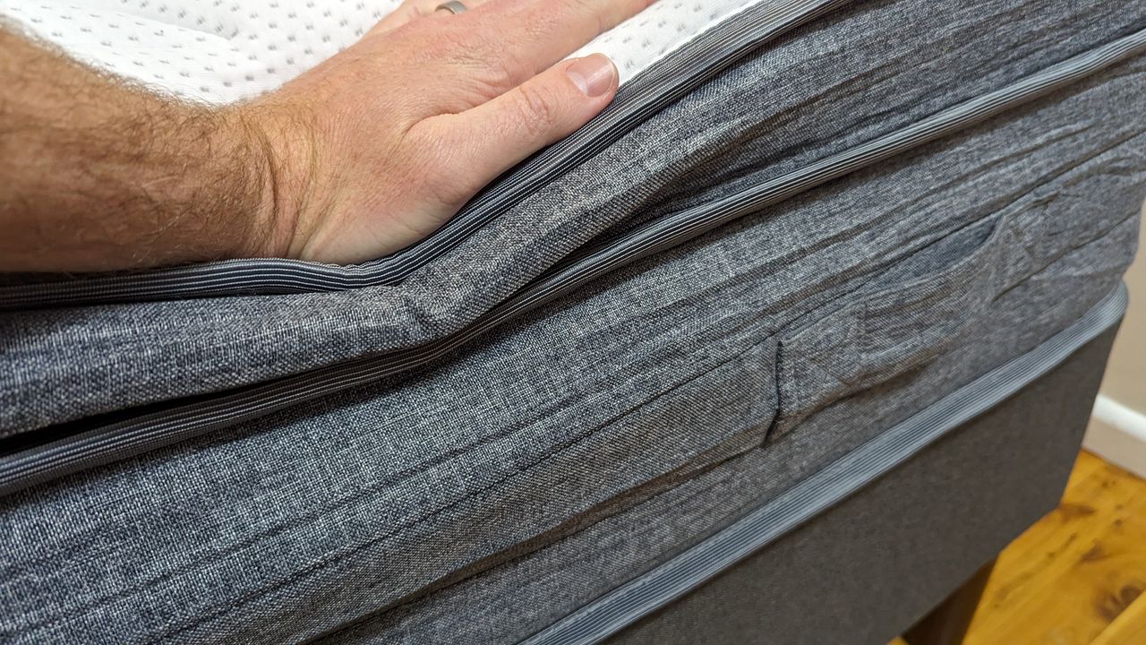 A hand pressing down on the Eva Comfort Classic mattress