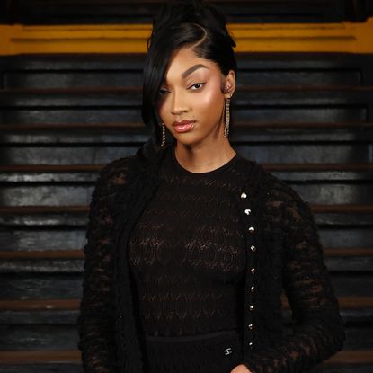 Angel Reese attended the Chanel runway show in a sheer little black dress and a matching Chanel bag