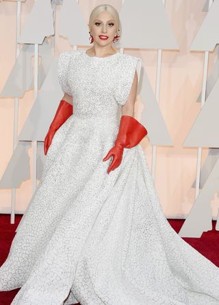 Lady gaGa wearing an Alaia gown and red rubber gloves at the Oscars