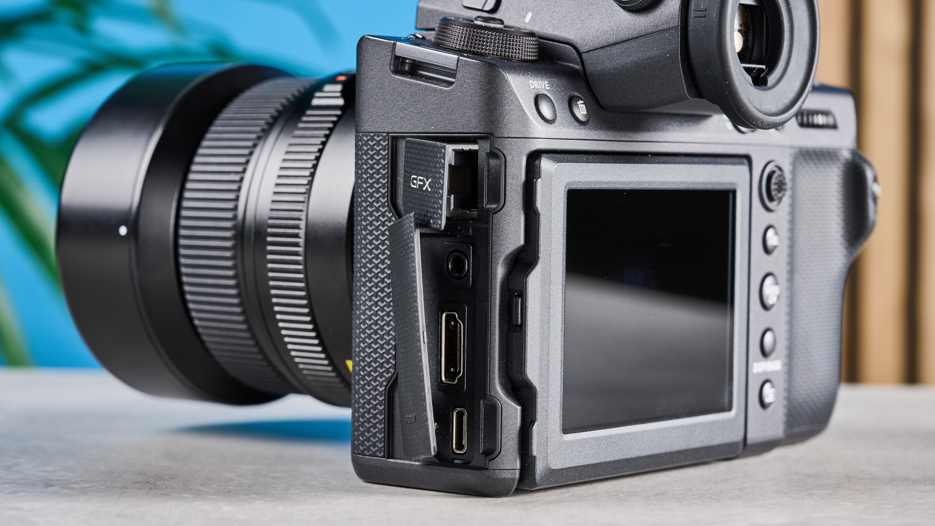 The Fujifilm GFX100 II side, with its accessories hatches open and ports on display