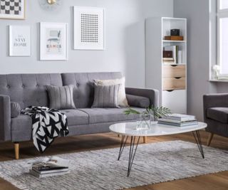 A gray living room set with cozy throw and rug.