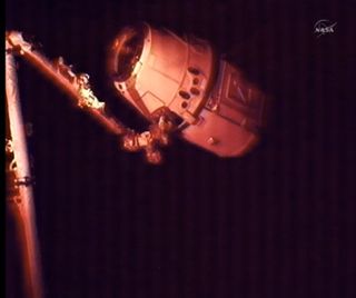 SpaceX's Dragon space capsule and space station pass into night.