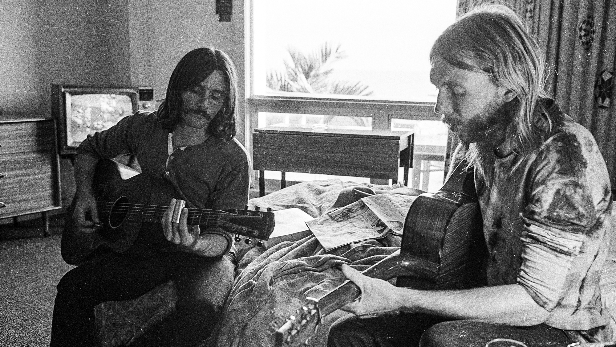 SPARTANBURG, SC - OCTOBER 17: Guitarists Duane Allman (R) and Dickey Betts use a steel slide on an acoustic guitars in a hotel room before the Allman Brothers' performance at the Sitar on October 17, 1970 in Spartanburg, South Carolina.