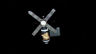 the space station with four large solar arrays looking like a some sort of space windmill against the black background of space.
