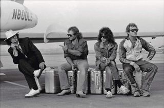 Van Halen sitting on suitcases on the tarmac at an airport