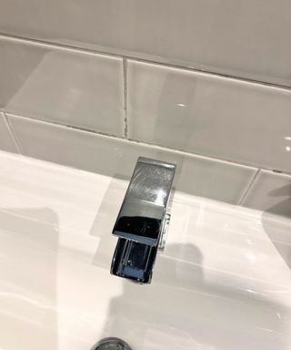 Sparkling bathroom faucet with grey tiles