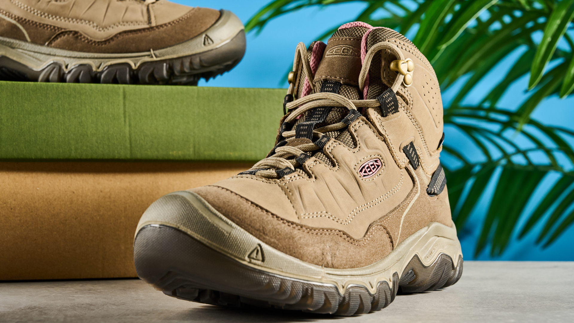 Keen Targhee IV hiking boots photographed in front of a blue background.