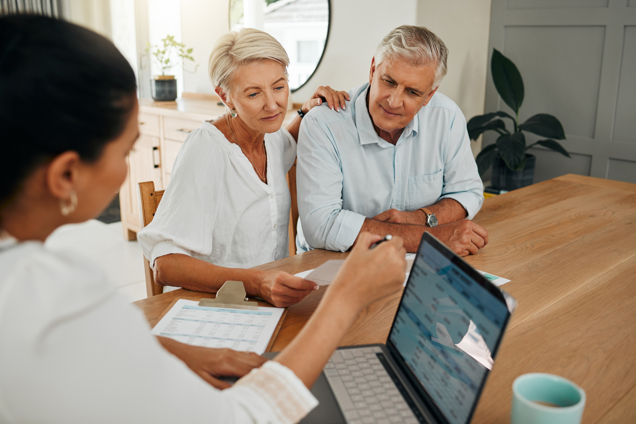 Older couple discussing finances with a female financial adviser