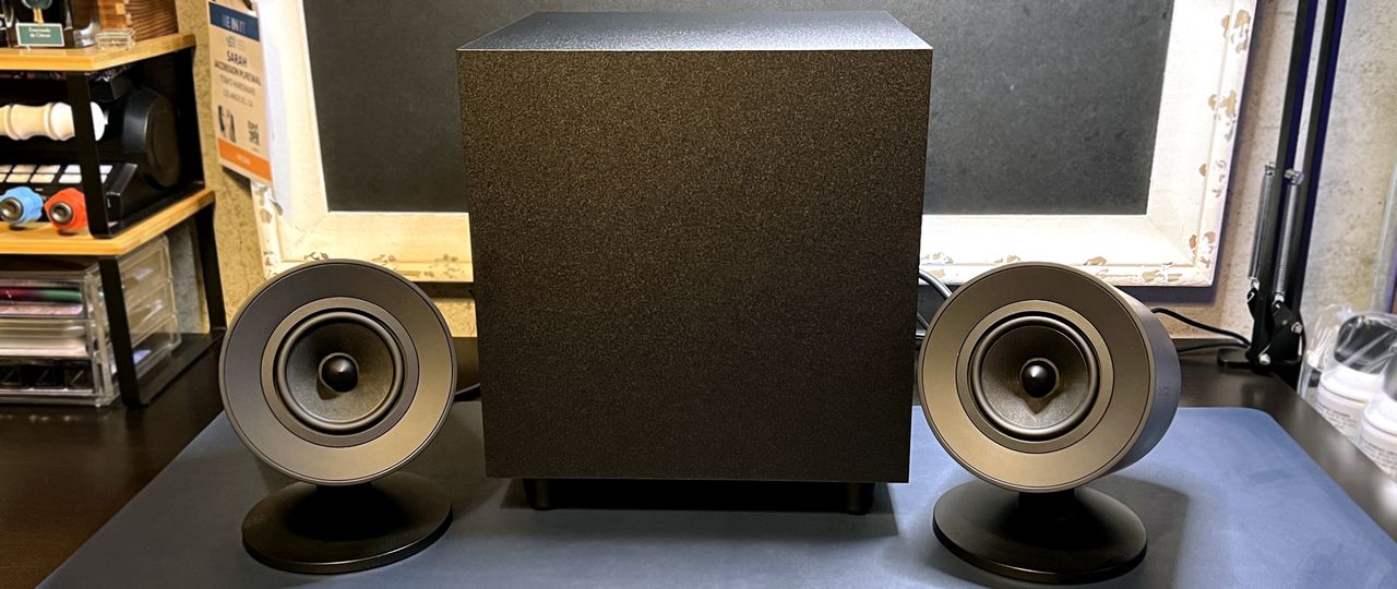 Razer Nommo V2 speakers on desk with subwoofer.