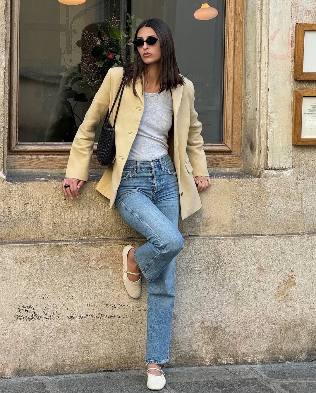 Influencer @salome.mory wears straight-leg pale jeans with a suede blazer and white Mary Jane flats.
