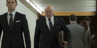 Christian Bale as Dick Cheney walking down a hallway in Vice