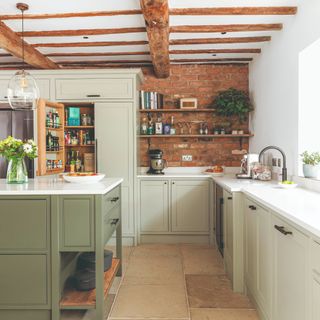 Kitchen with ceiling beams and green cabinetry