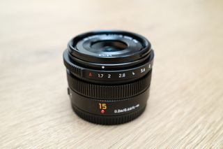 Panasonic Leica Summilux DG 15mm f/1.7 ASPH on a wooden table.