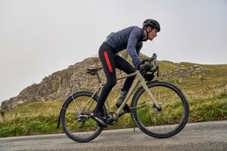 Image shows a person riding a bike with mudguards attached.