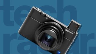 A Sony compact camera - one of the best travel cameras - on a blue background