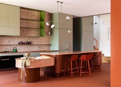 modern kitchen with pink, green and orange tones and a round kitchen island
