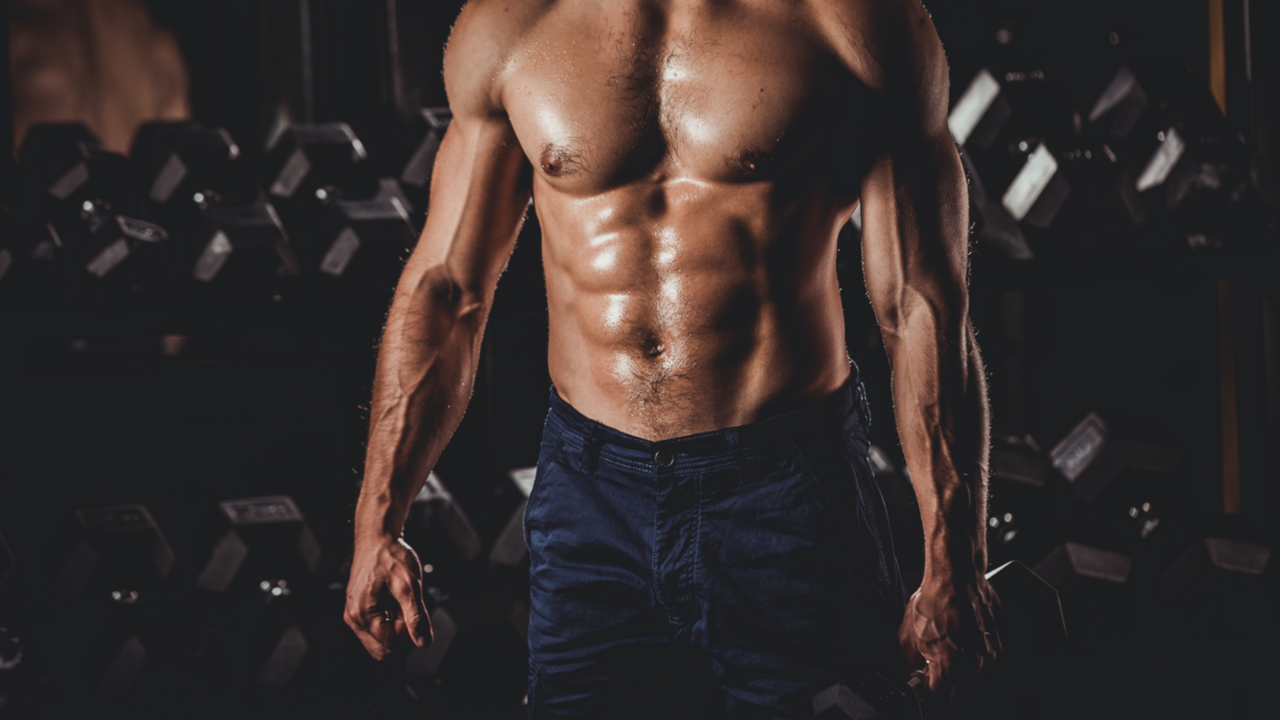 Man with chest out and holding a dumbbell