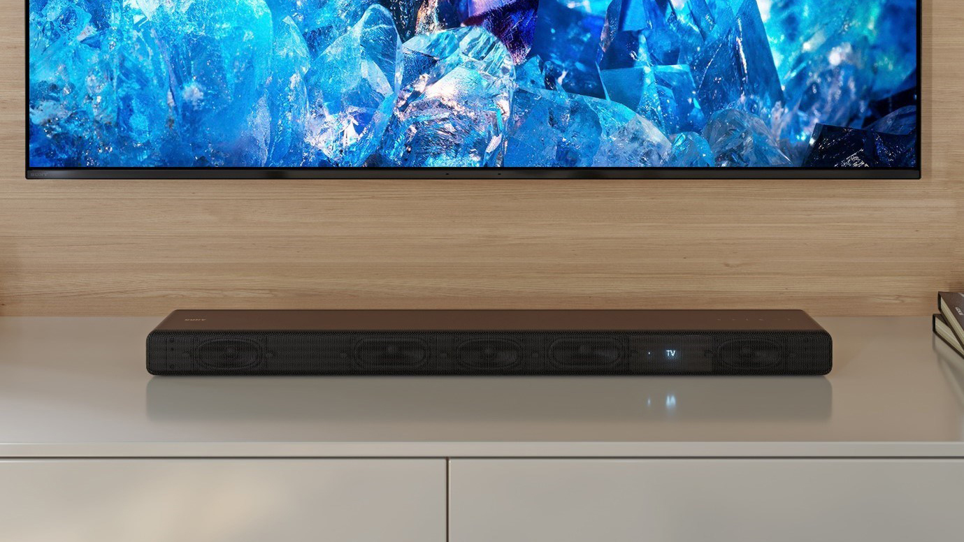 Sony HT-A3000 liggende på en TV-benk under en TV