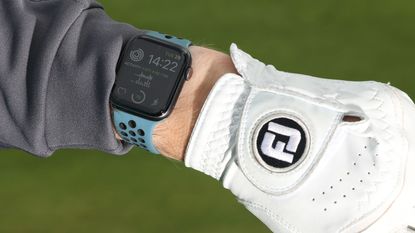 A golfer checking an Apple Watch