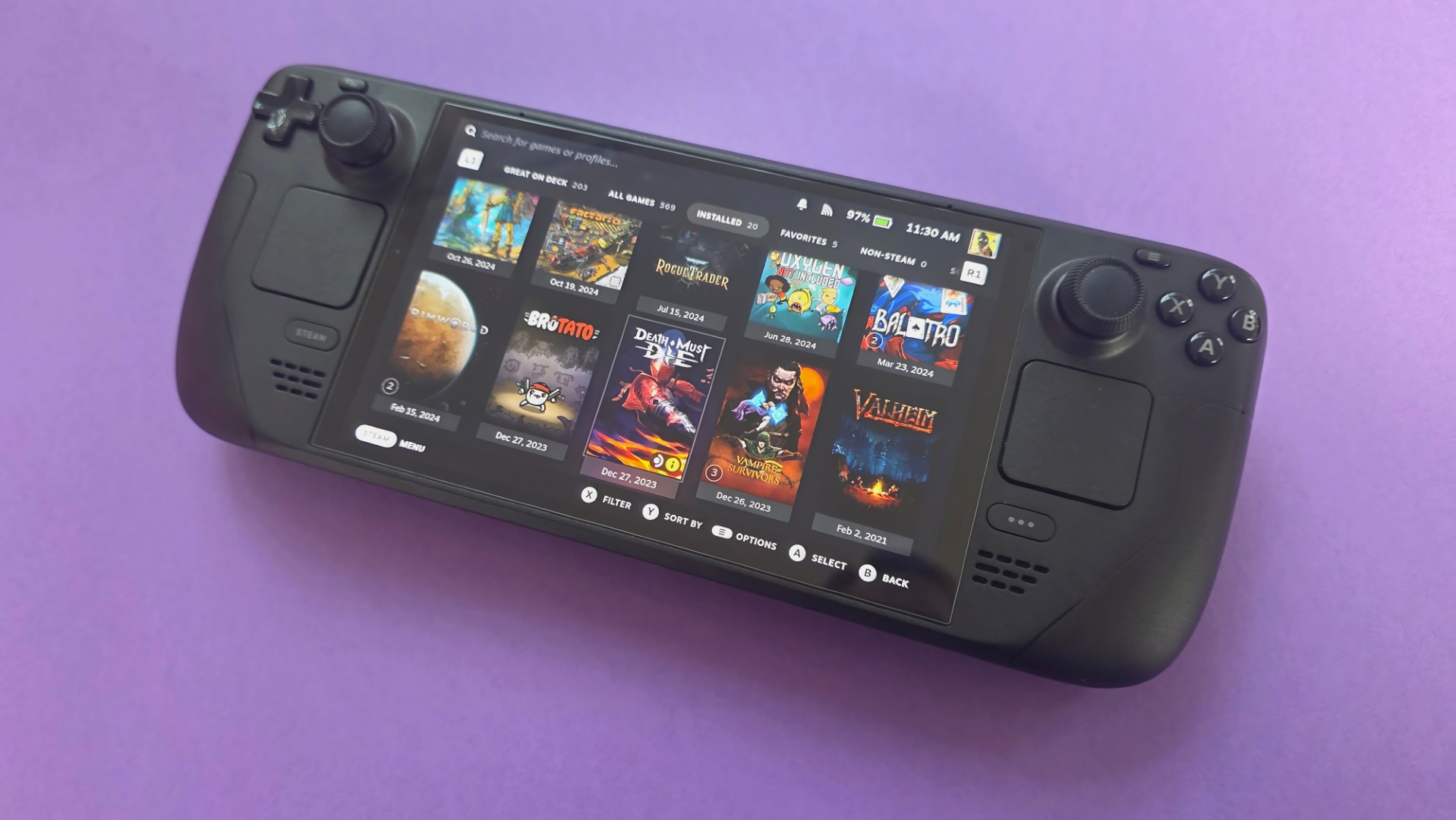 A Steam Deck OLED handheld gaming console on a solid purple background