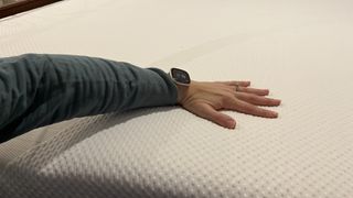 Tempur-Cloud mattress review image shows our main tester exploring how cool the cover felt after sleeping on it