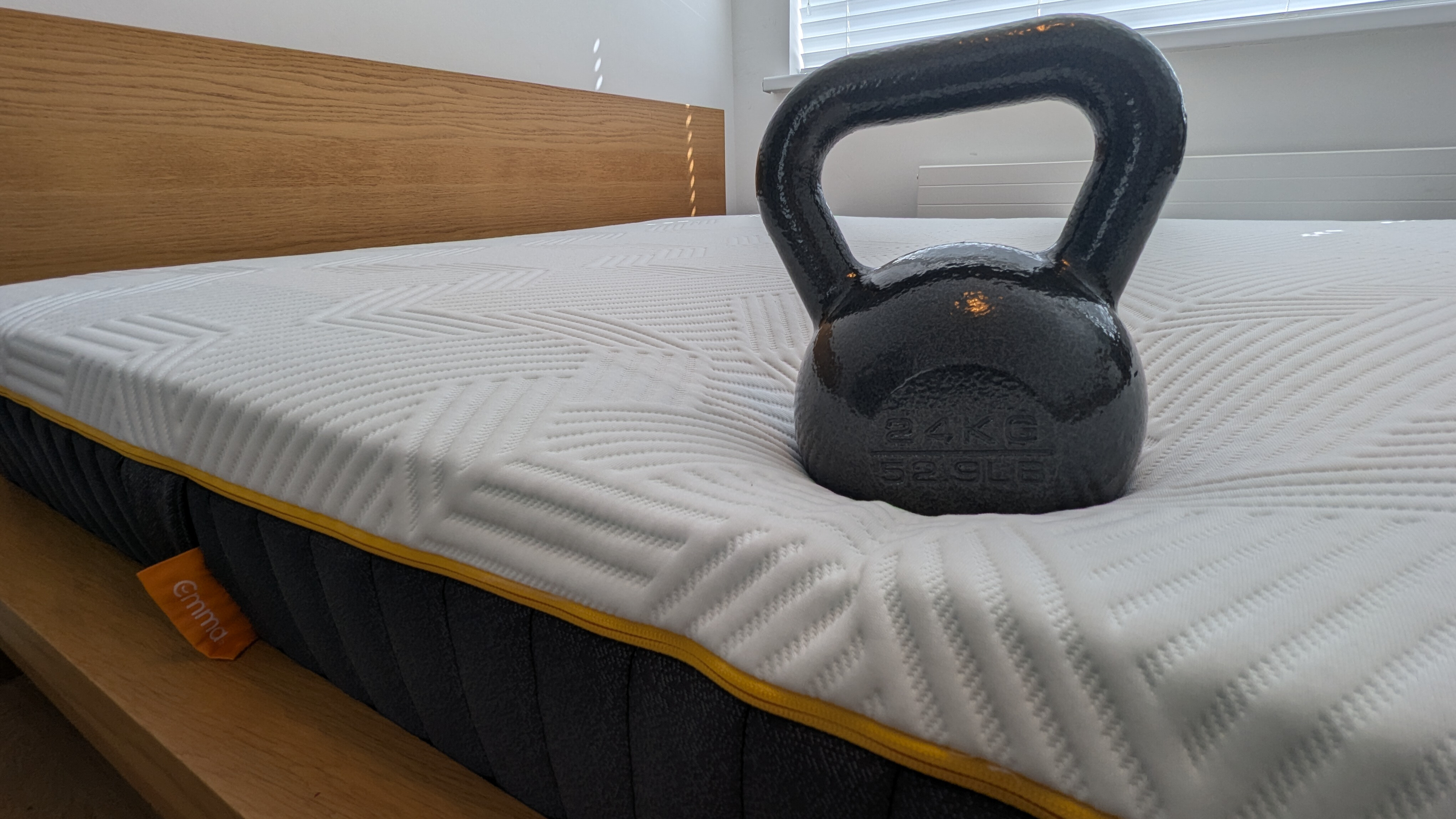 A 56lbs weight sitting at the edge of the Emma Hybrid Airgrid mattress