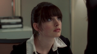 Anne Hathaway as Andy Sachs looking up from desk at Emily Blunt's Emily (not pictured) in The Devil Wears Prada
