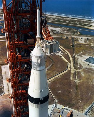 Swing arm 9 is seen in use, extending from Launch Umbilical Tower-1 to the Apollo command module atop the Saturn V rocket, prior to the launch of Apollo 11 in 1969.