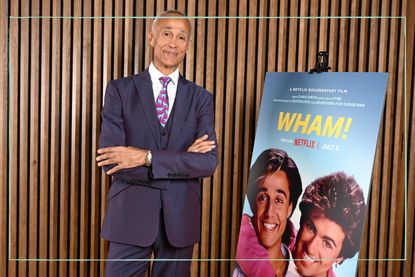 Andrew Ridgeley stood next to a poster of the Wham! documentary