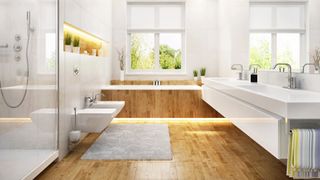 contemporary bathroom with laminate wood flooring and wooden bath surround with white bathroom suite