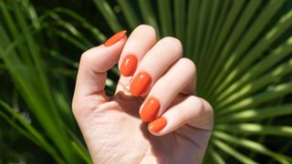 A hand with orange nials