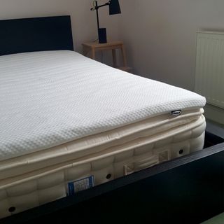 The IKEA NISSEHOLM mattress topper being tested over a mattress