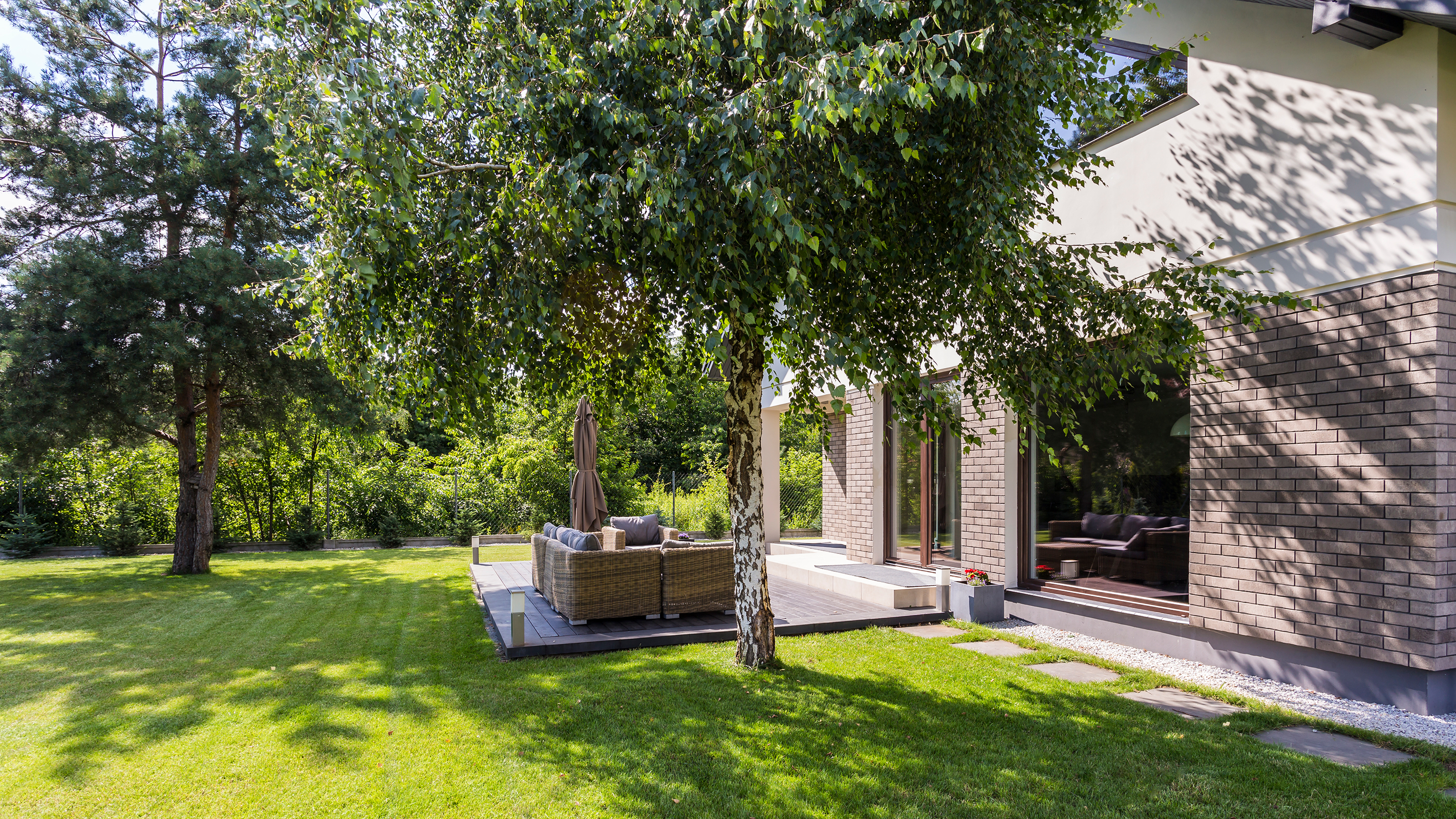 garden with seating area covered by large trees