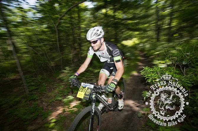 Mike Festa riding through a shaded section of trail.